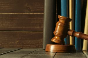 Gavel With Books On Old Wooden Desk